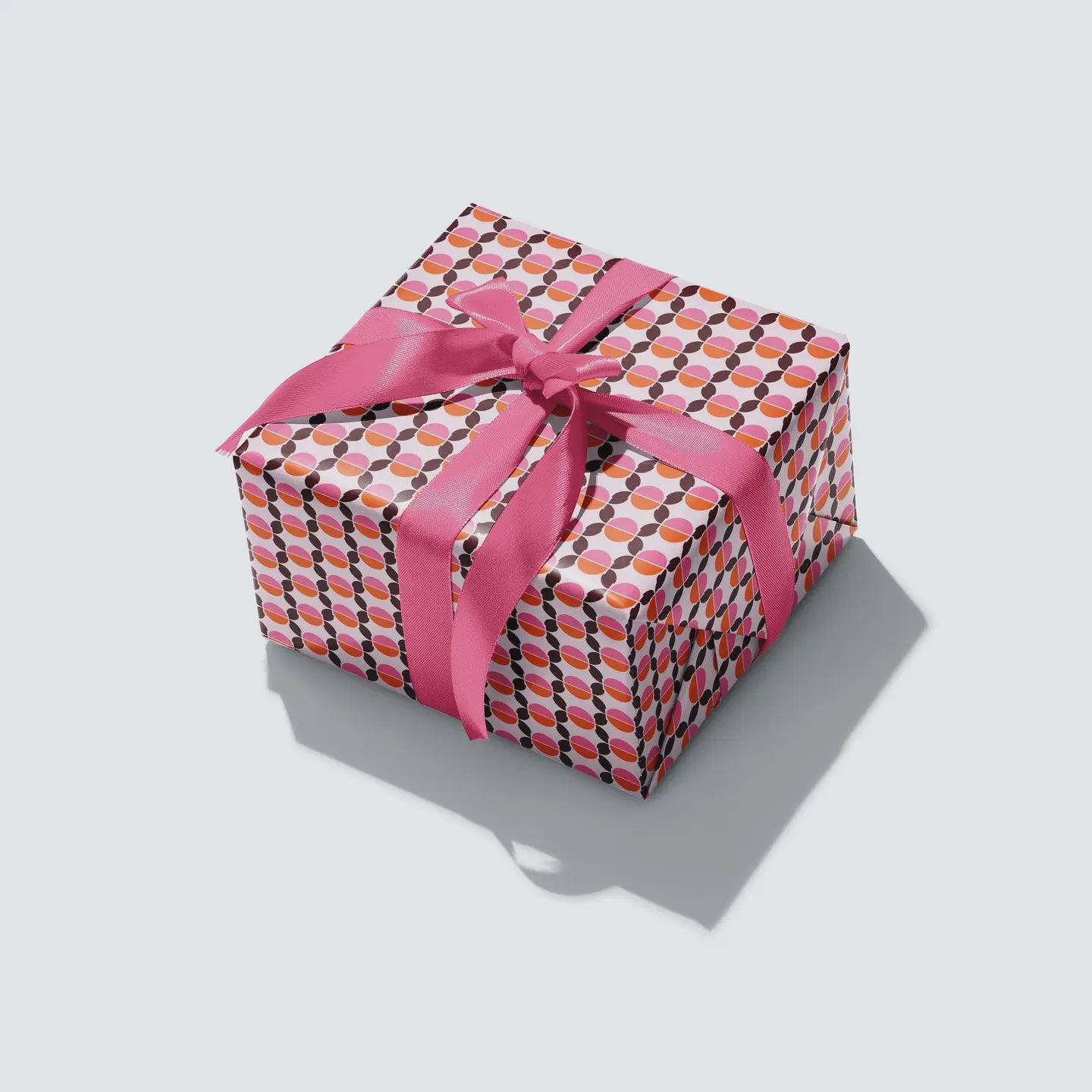 Seventies Wrapping Paper with geometric circular design and retro pink, orange and brown colours.